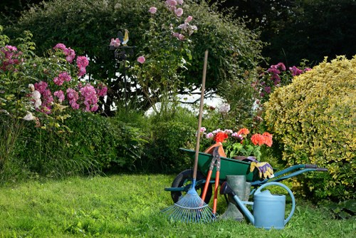 Gardener with safety helmet and high-visibility vest inspecting a front garden in Vauxhall